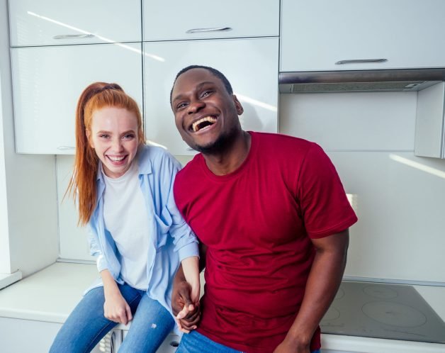 african american man and redhaired ginger woman dancing at kichen and feeling good mood.mixed race couple newlyweds.